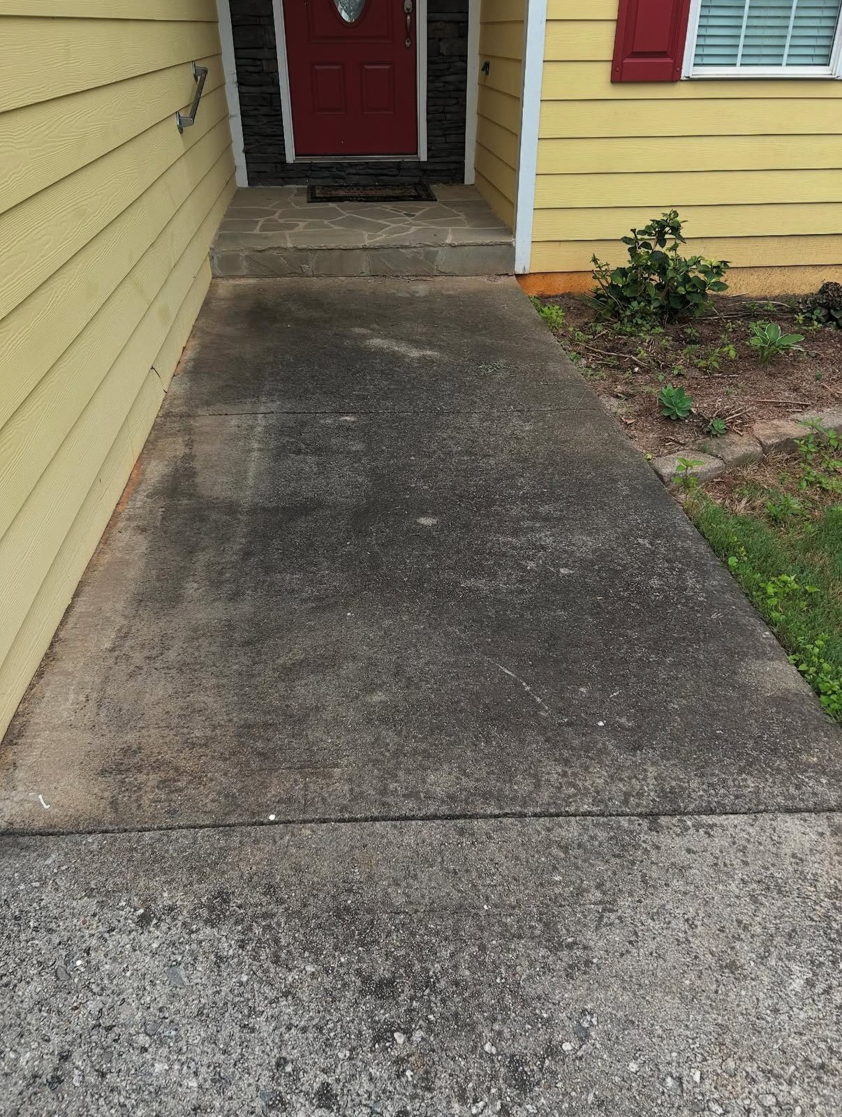 Dark stained front walkway before pressure washing in Athens, GA