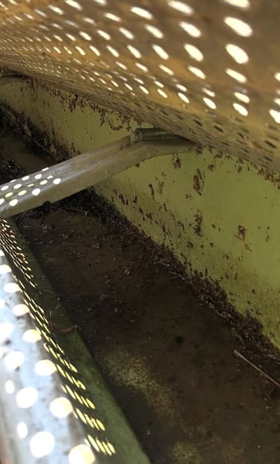 Gutter filled with sludge and debris before cleaning in Athens, GA