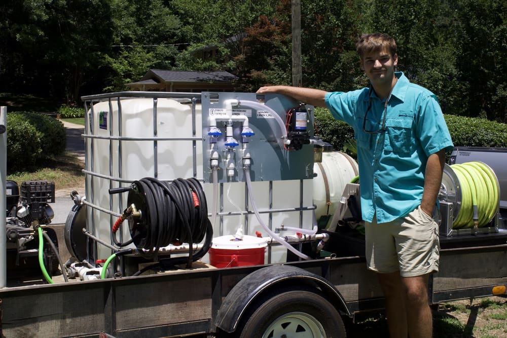 The owner of O.N.B Pressure Washing beside his trailer at an Athens home